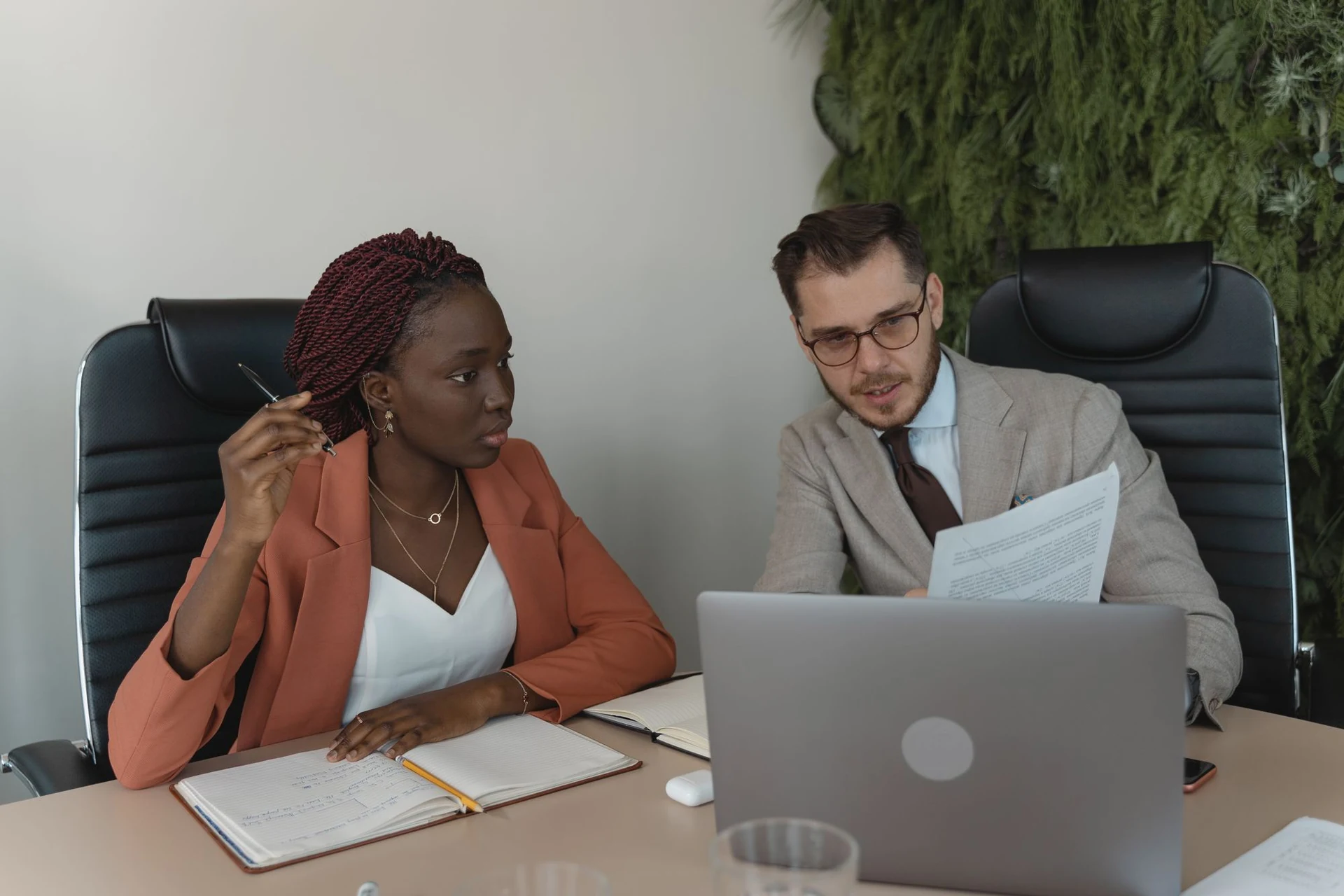 Two people discussing documents in a business consultation